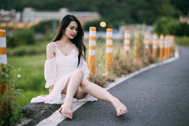 Photo young woman sitting on road