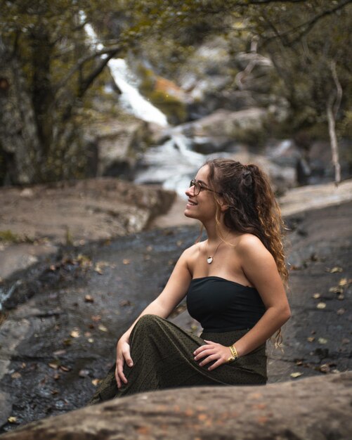 Photo young woman sitting on rock