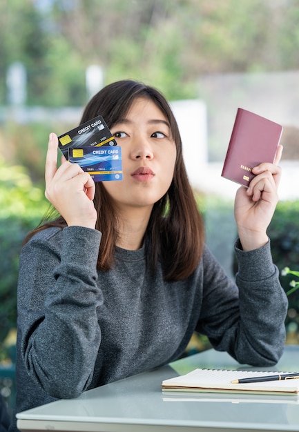 사진 젊은여자가 앉아 보여주는 여권 및 신용 카드