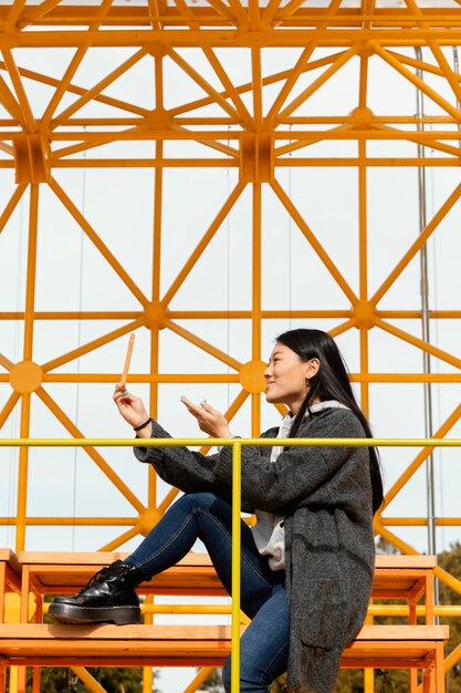 サイト建設橋に座っている若い女性