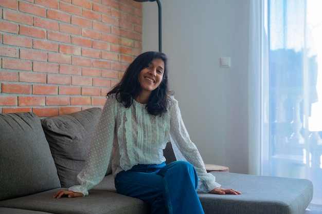 Foto giovane donna seduta e sorridente a casa