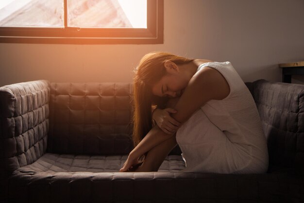 Foto giovane donna seduta sul divano a casa