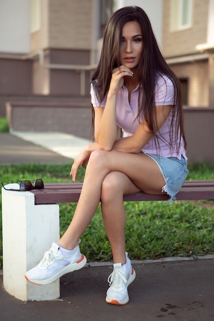 Photo young woman sitting on a street bench