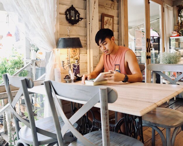 Photo young woman sitting on table at home