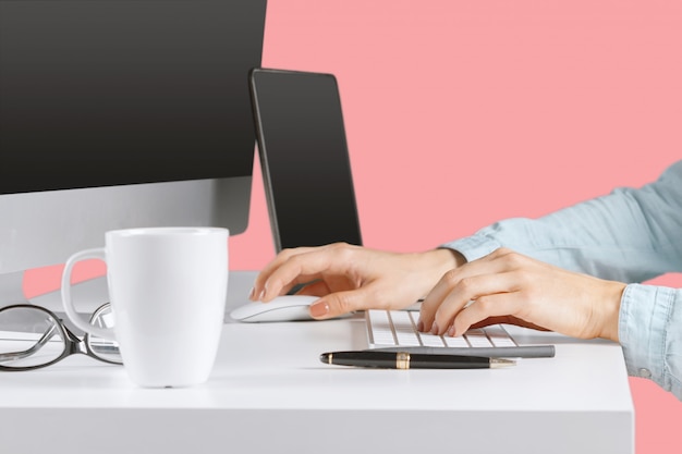 Young woman sitting at the table with open netbook computer. 