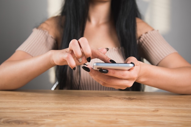 Young woman sitting at the table with the phone