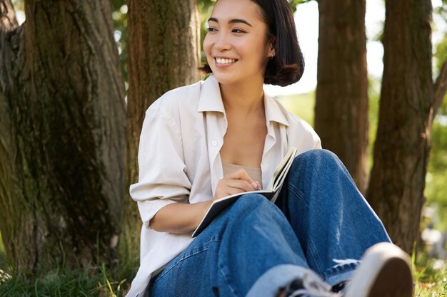 Молодая женщина сидит на стволе дерева