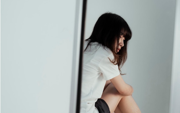 Young woman sitting on wall at home
