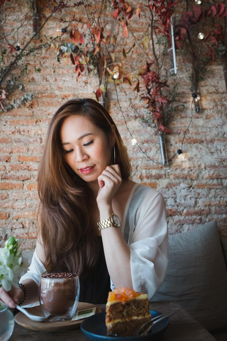 Photo カフェのテーブルで熱い飲み物を飲んで座っている若い女性