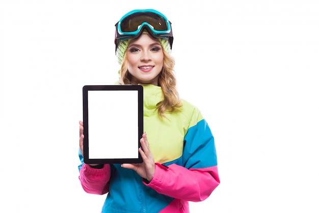 Young woman in ski suit show empty tablet