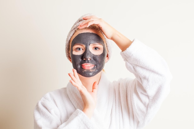 Young woman at skincare cleansing procedure at cosmetology salon Cosmetic black mask