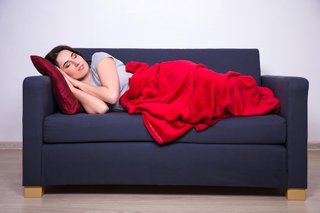 Young woman sleeping on sofa at home