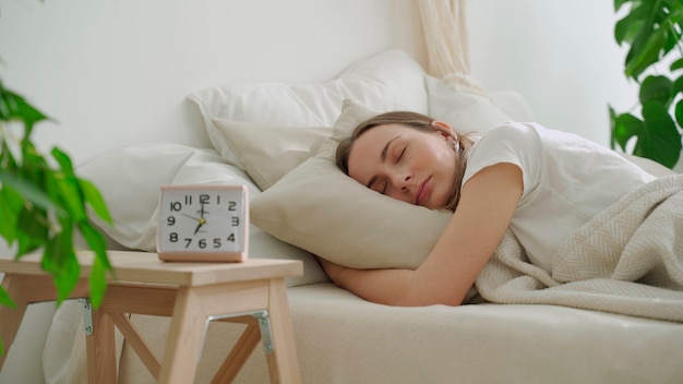 Young woman sleeping on white pillow in bed woman peacefully sleeping in bed