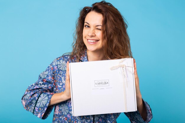 Young woman smiling against blue background