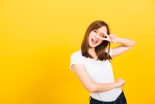 Young woman smiling against yellow background