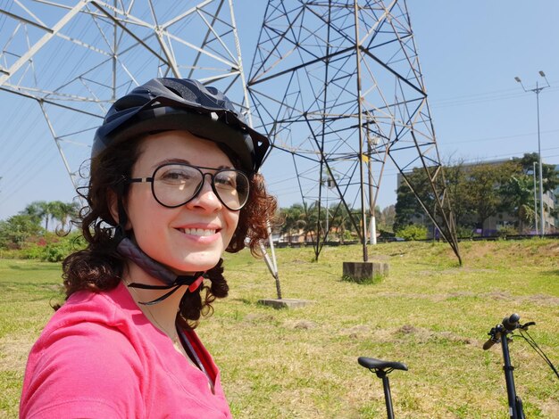 자전거에 헬멧을 쓰고 자전거 길에서 웃고 있는 젊은 여성