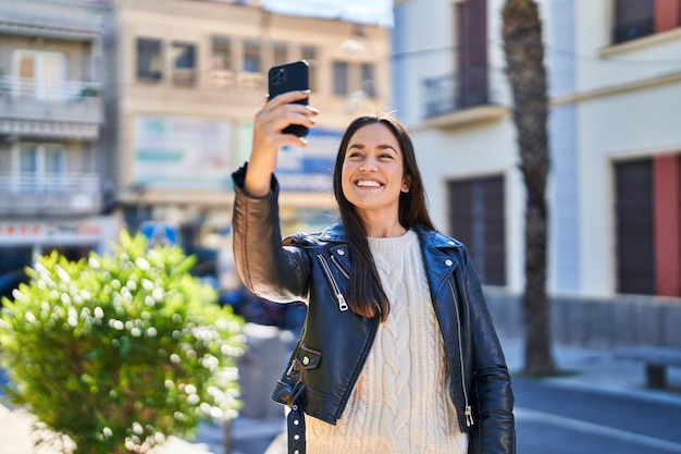 Young woman smiling confident make selfie by the smartphone at park