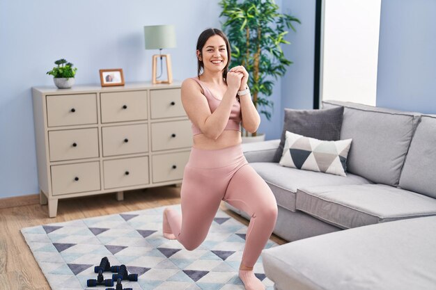 Young woman smiling confident training legs exercise at home