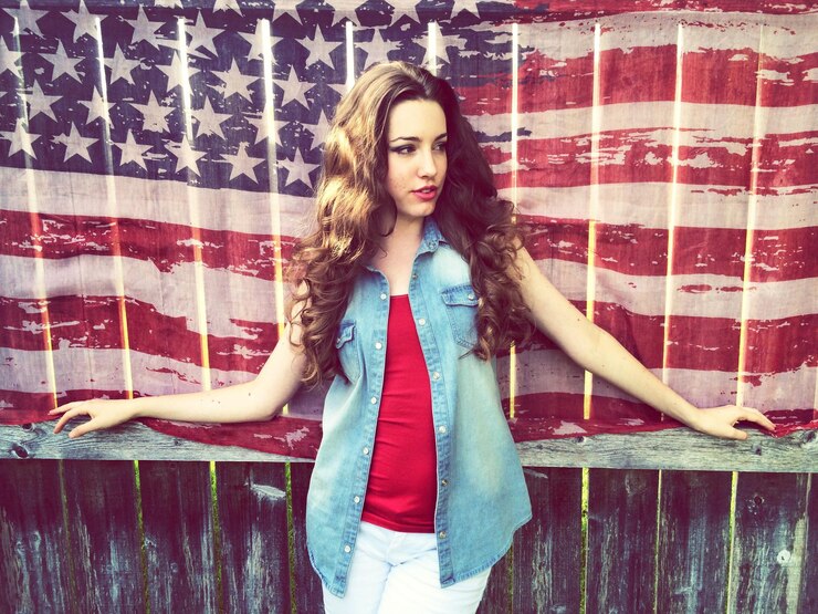 Photo young woman smiling in front of us flag