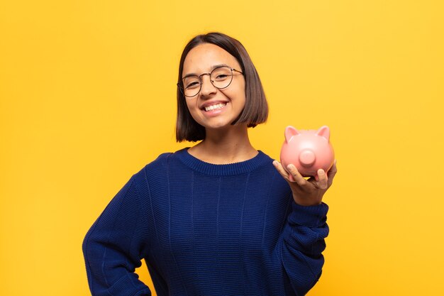 Young woman smiling happily with a hand on hip