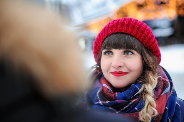 Young woman smiling to her boyfriend outdoors on winter day