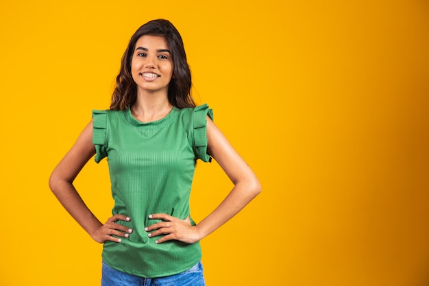 Young woman smiling looking at camera on yellow background.