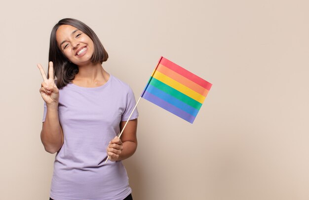 Giovane donna sorridente e dall'aspetto amichevole, mostrando il numero due o il secondo con la mano in avanti, conto alla rovescia