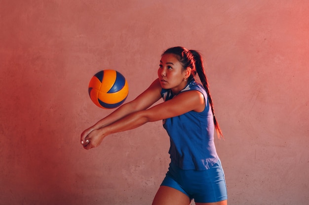 Молодая женщина улыбается волейболист с мячом.