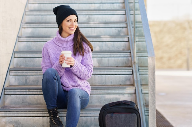 Young woman smiling while sitting on steps