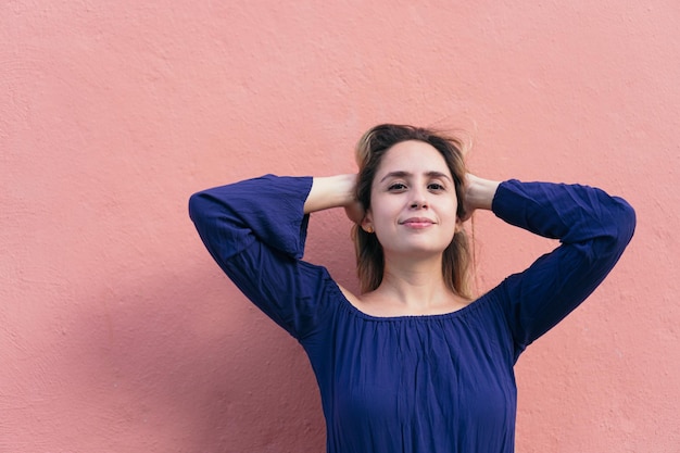 Young woman smiling with hand on head