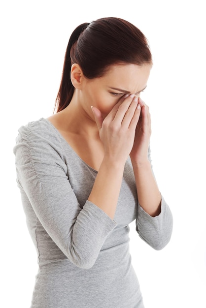 Photo young woman sneezing against white background