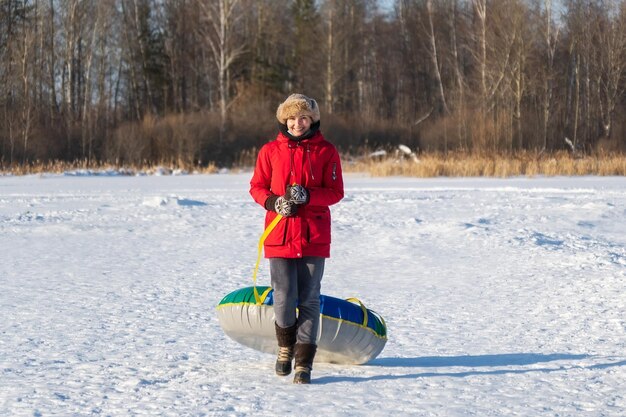 Young woman snow tube in winter park Leisure on nature snow slide skiing Concept of interactive entertainment selective focus