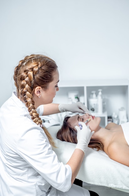 Young Woman At Spa Clinic Receiving Facial Stimulating Treatment