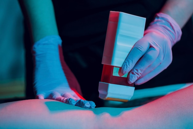 Young woman in Spa getting legs waxed for hair removal