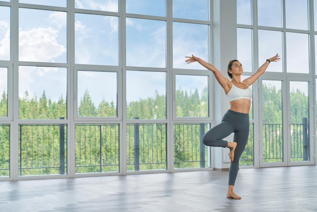 Young woman in sport outfit doing fitness at hall