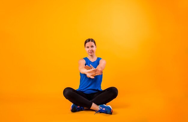 Young woman in sports uniform exercises