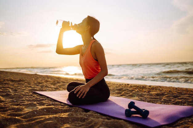 Young woman in sportswear doing yoga fitness exerciseon the beach Sport Active life