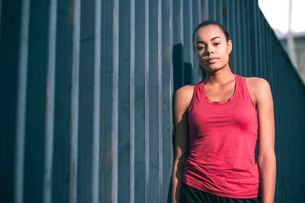 Photo young woman in sporty shirt standing near the slate fence. website banner