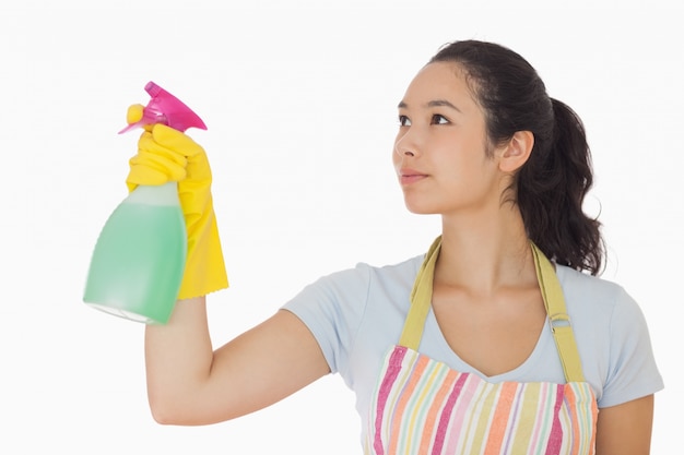 Young woman spraying cleaner