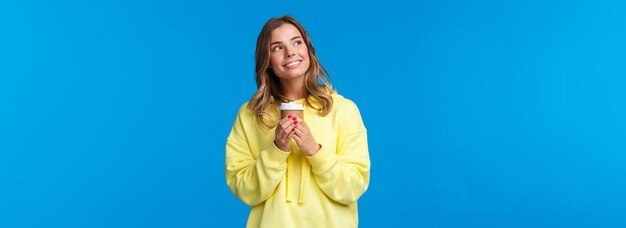 Young woman standing against blue background