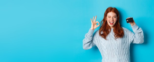 Foto giovane donna in piedi sullo sfondo blu