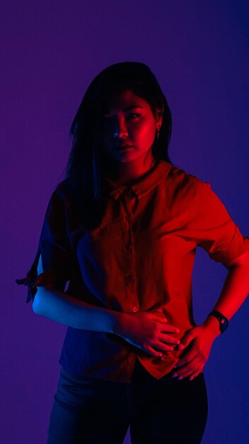 Young woman standing against blue background