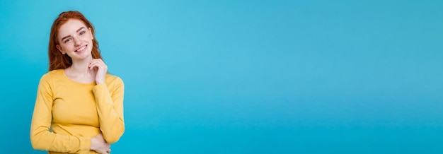 Young woman standing against blue background