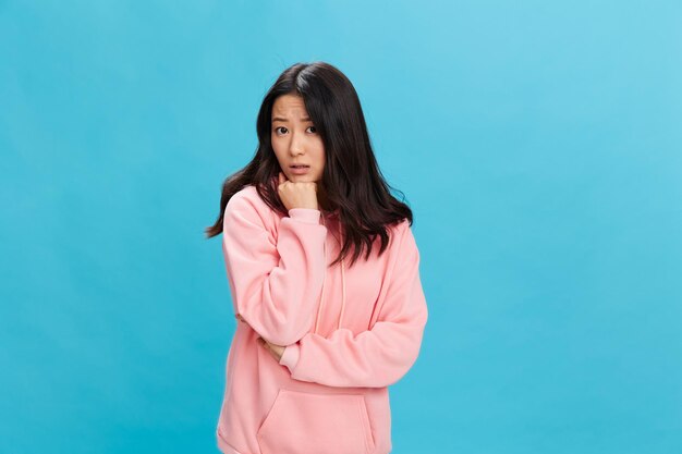 Young woman standing against blue background