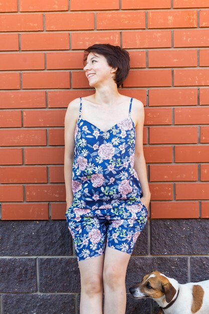 Photo young woman standing against brick wall