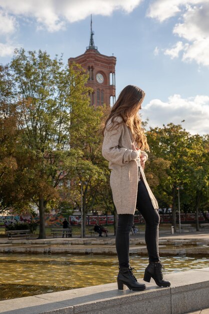 Foto giovane donna in piedi contro un edificio in città