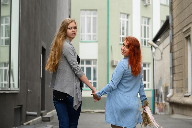 写真 街の建物に立っている若い女性