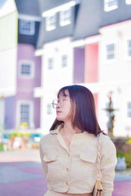 Young woman standing against building