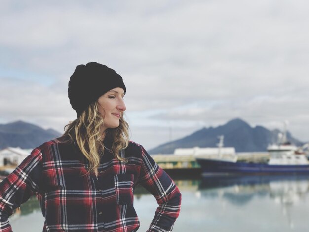 Photo young woman standing against dock