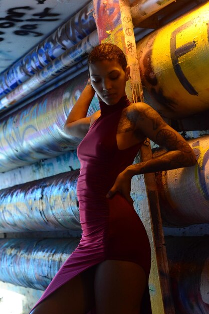 Young woman standing against graffiti wall